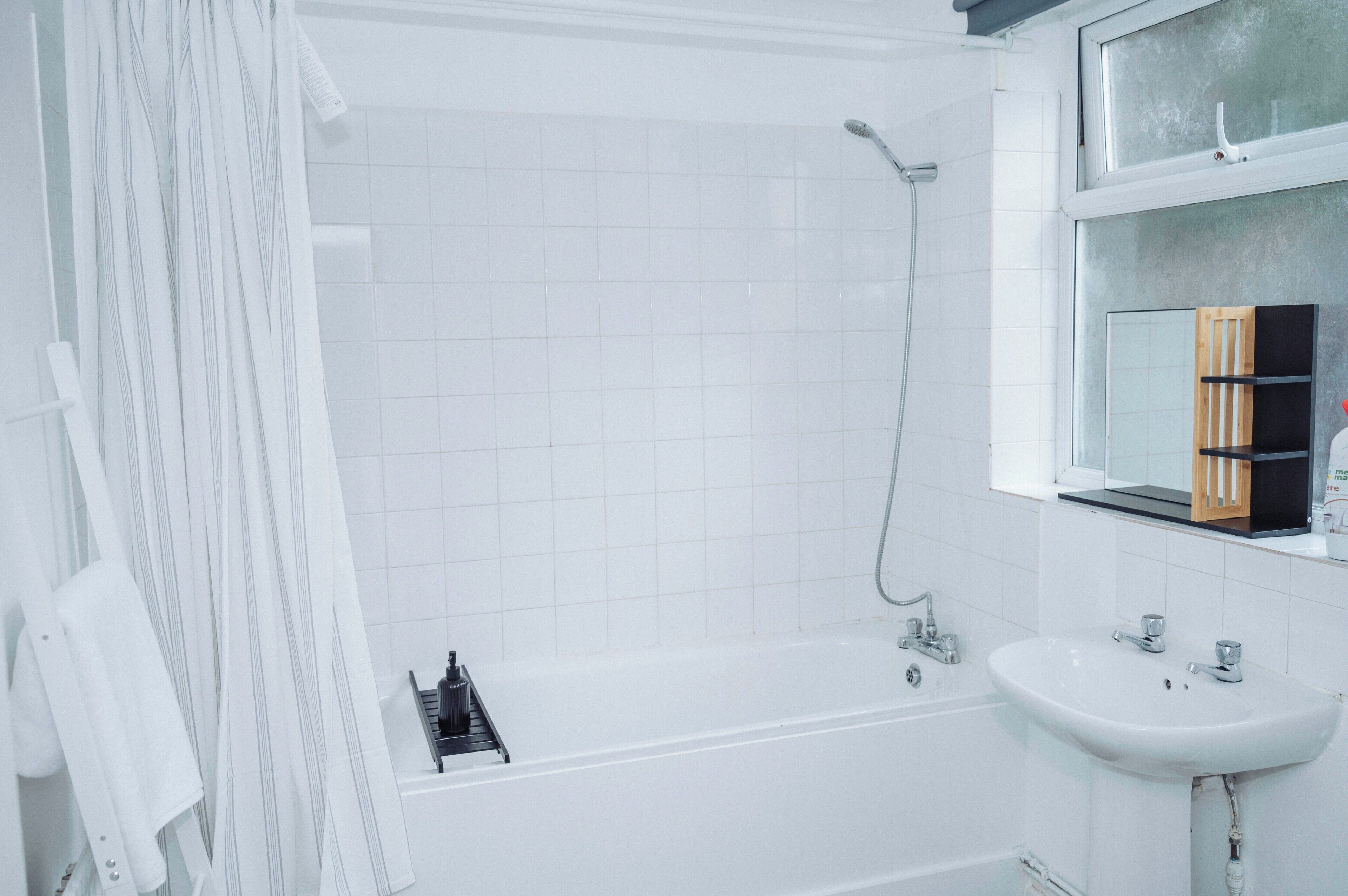 A modern bathroom with a bathtub, a sink, and a mirror.