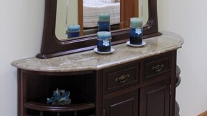 Un tocador de baño con espejo, lavabo y un armario.
