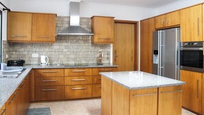 Una cocina moderna con armarios de madera, un refrigerador de acero inoxidable y un horno empotrado.