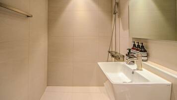 A modern bathroom with a shower, a sink, and a mirror.