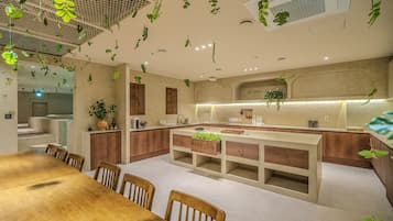 A modern kitchen with wooden cabinets, a central island, and hanging plants.