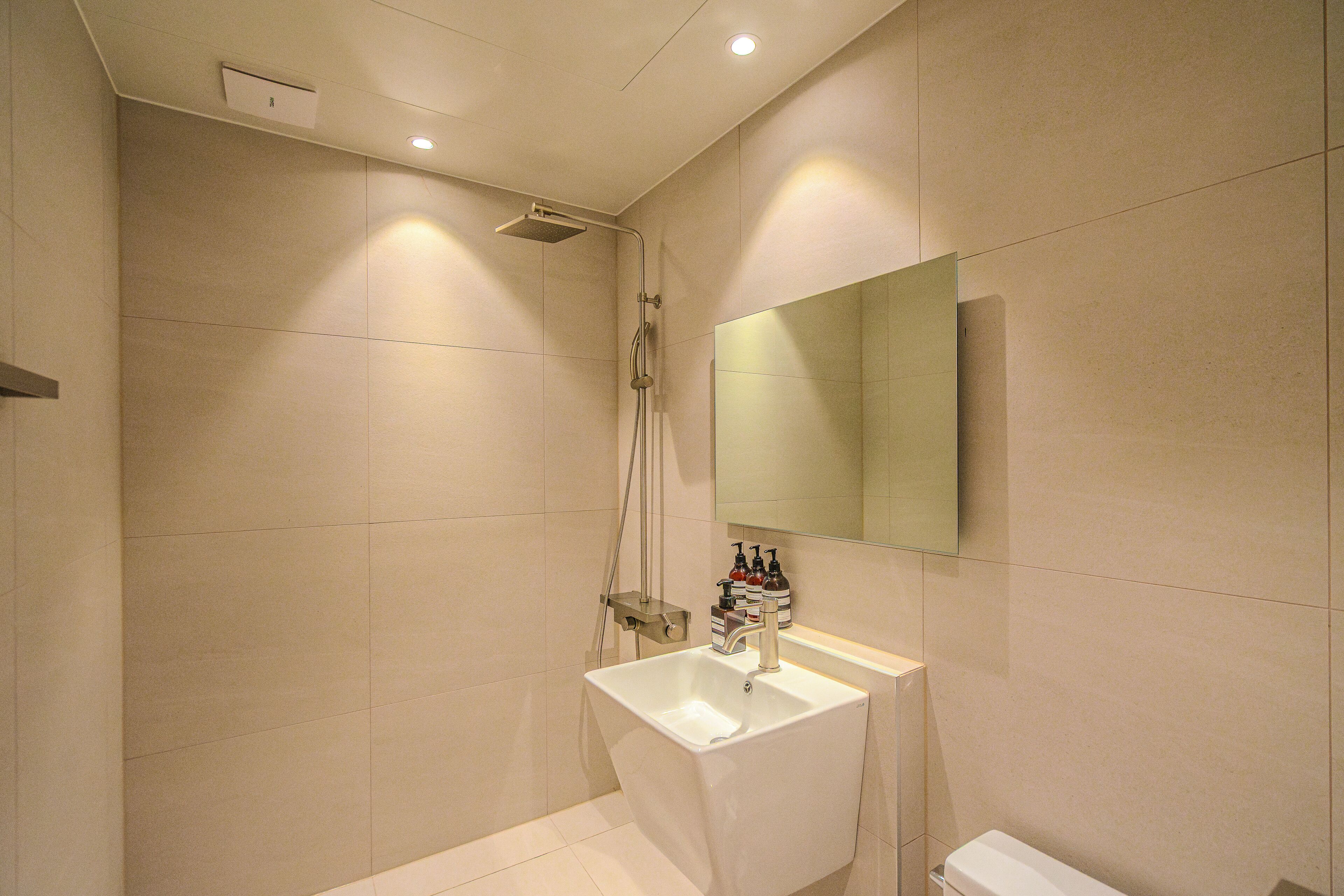 Un baño moderno con ducha, lavamanos e inodoro.