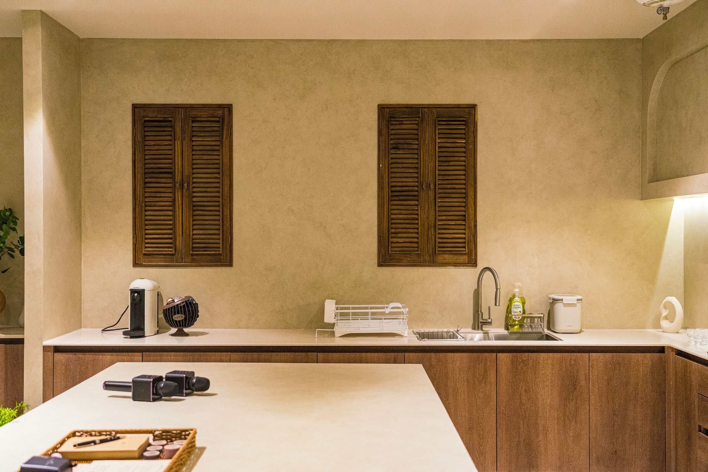 Una cocina con armarios de madera, encimera blanca y horno empotrado.
