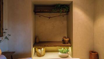 A shelf with a plant, two vases, and a candle holder.
