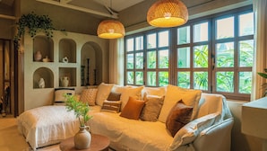 A cozy living room with a large sofa, a coffee table, and a bookshelf. - Maison de On U Hotel Gwangju cheomdan (Gwangju)