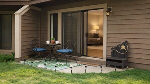 A patio with two chairs and a small table, a potted plant, and a star decoration on a fence. - Escape to Tranquility at Mountain Top Condo! (Somerset)