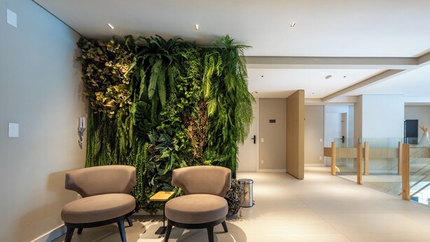 Un intérieur moderne avec deux fauteuils beige, un présentoir à plantes fixé au mur et un design épuré et minimaliste.