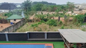 Un área de piscina en la azotea con un trampolín, una piscina pequeña y una zona de estar con mesas y sillas.