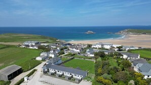 Vista aérea de un pueblo costero con casas, una playa y el mar.