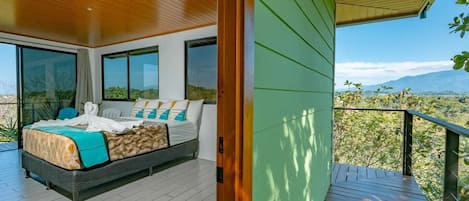 Un dormitorio moderno con una cama grande, un balcón y vistas al paisaje.