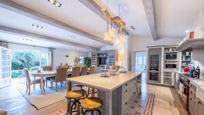 A spacious kitchen with a large island, modern appliances, and a view to the outdoors. - Magnificent Villa near Fayence (Saint-Paul-en-Forêt)