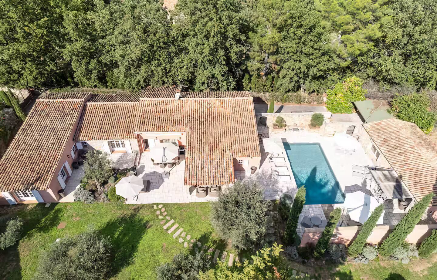 Eine Übersichtsaufnahme eines Anwesens mit Schwimmbad, gepflasterten Dächern und Garten.