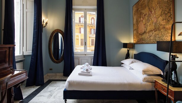 A neatly made bed with white linens, a large mirror, a wooden dresser, and a painting on the wall. - [5 Bedrooms, 3 bathrooms] Historic residence in Coliseum (Roma)