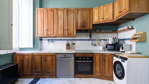 A kitchen with wooden cabinets, a dishwasher, an oven, a microwave, and a washing machine. - [5 Bedrooms, 3 bathrooms] Historic residence in Coliseum (Roma)