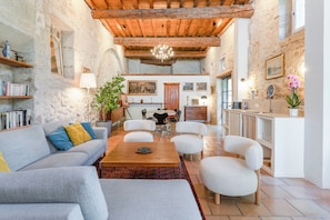 A cozy living room with a sofa, chairs, a coffee table, and a dining area. - Le Clos des Chartreux (Villeneuve-lès-Avignon)