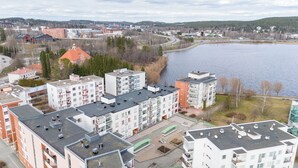 A high-rise residential building with multiple balconies, a rooftop terrace, and a view of a lake. - Lakefront Home near Downtown (Jyväskylä)