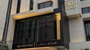 A modern hotel building with a prominent sign and large windows. - Ajm Mina Hotel (Makkah)