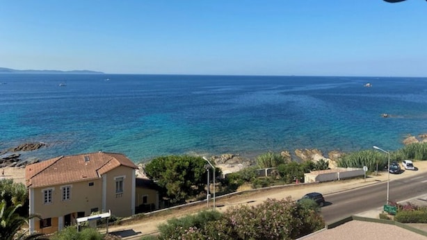 A coastal view with a house and a road.