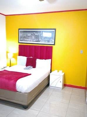 A hotel room with a bed, a nightstand, a lamp, and a framed picture on the wall. - Neo & ruks guest house Boston (Cape Town)