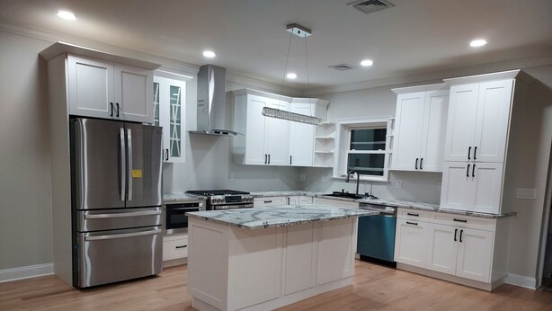A modern kitchen with white cabinets, stainless steel appliances, and a marble countertop. - Tranquil lakefront oasis - close to NYC and NJ attractions (Watchung)