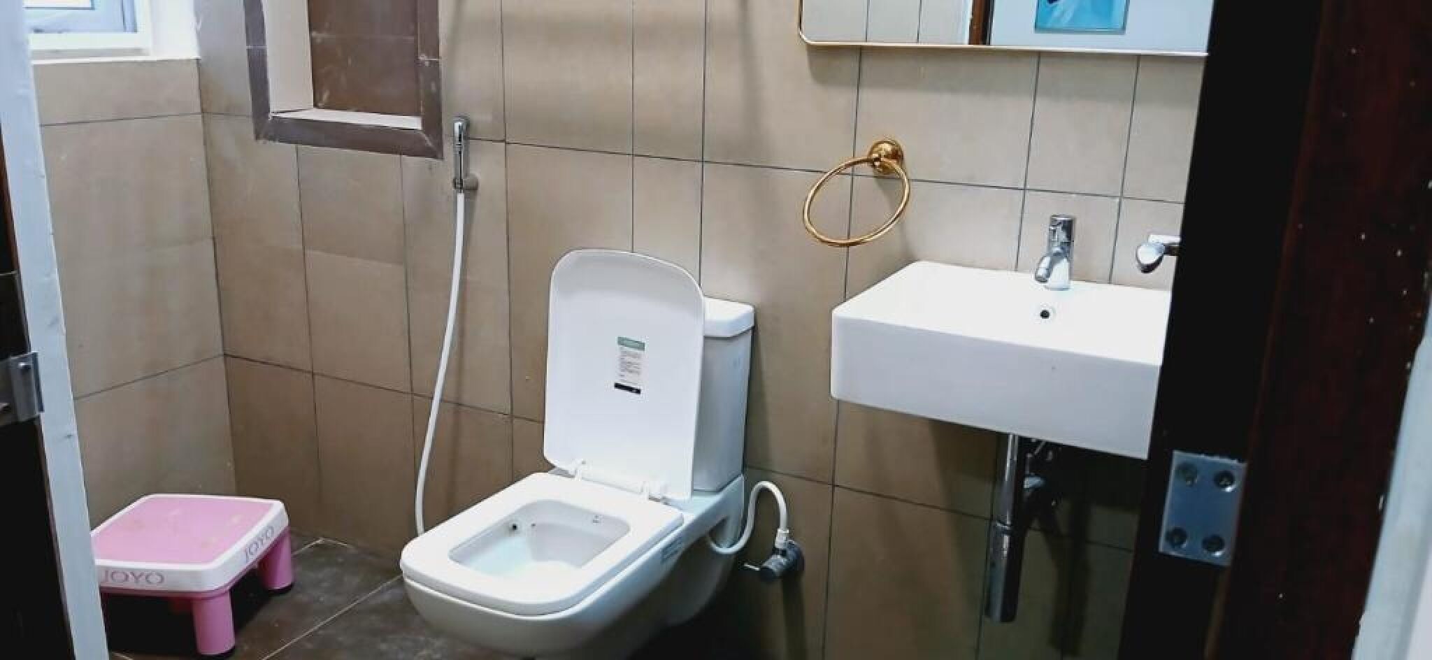 A small bathroom with a toilet, a sink, and a shower.