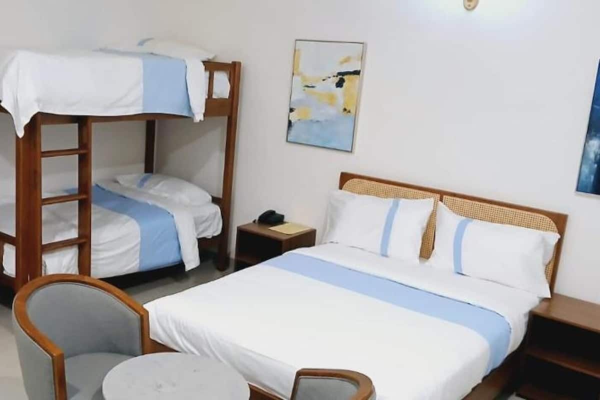 Ein Zimmer mit Stockbetten, einem Schreibtisch, einem Stuhl und einem Bett mit Kopfteil.