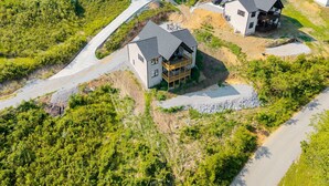 An aerial view of a residential area with two houses, one with a balcony and a driveway leading to a road. - Mountain Views, Lake access, Brand new 6 BR 5Bath, Sleeps 18Pet Friendly (Lafollette)