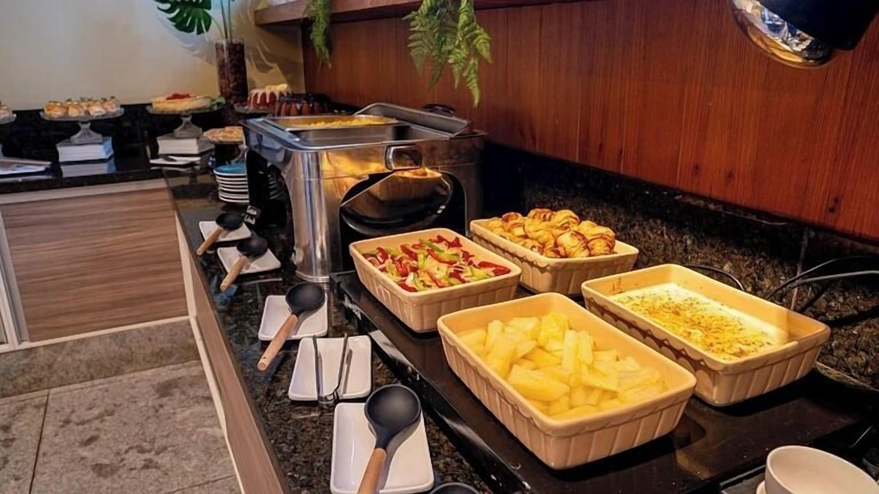 A buffet setup with various food items in trays, including what appears to be fruit and possibly some baked goods.