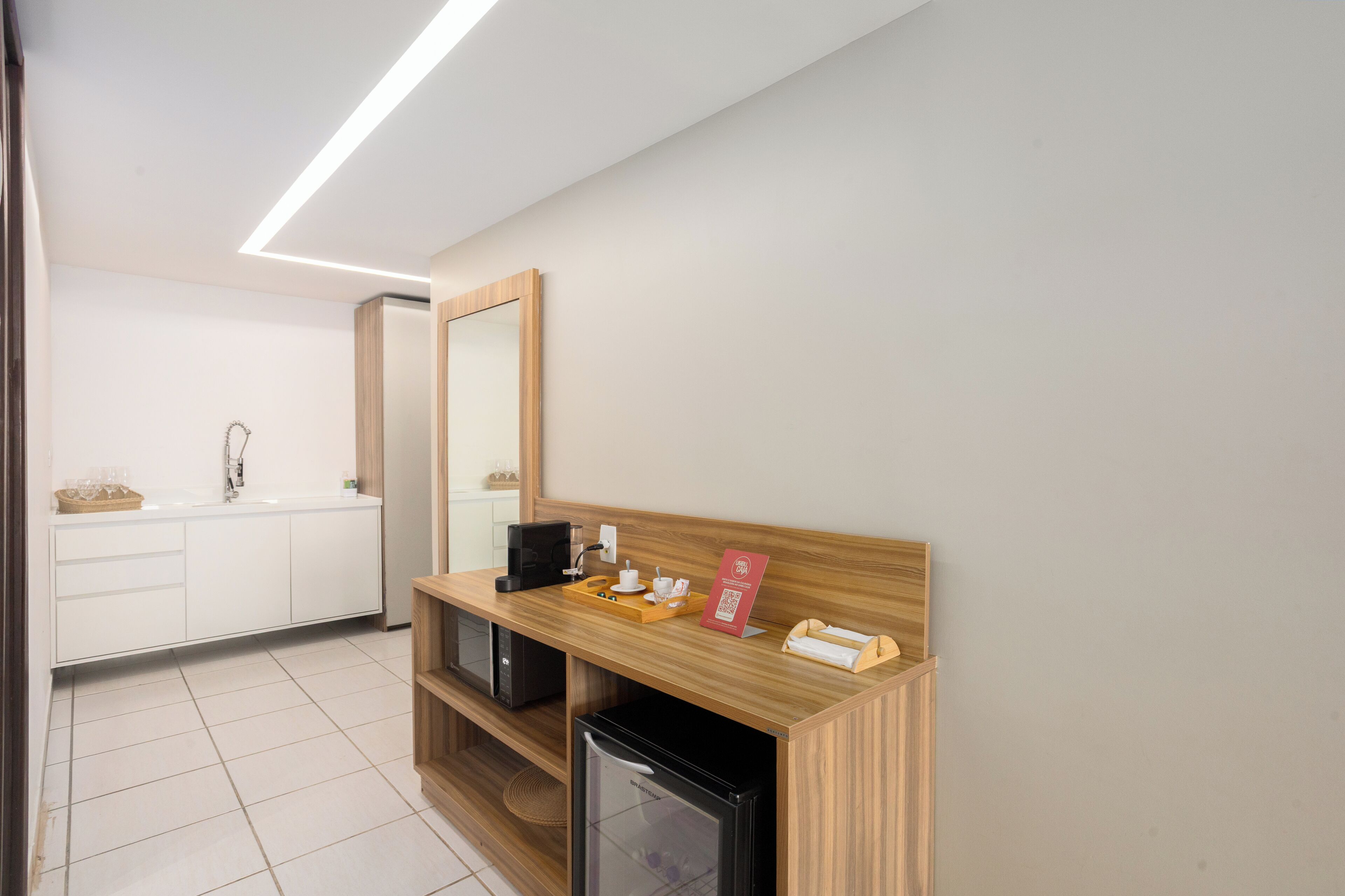 A modern bathroom with a wooden vanity, a sink, a mirror, and a coffee machine.