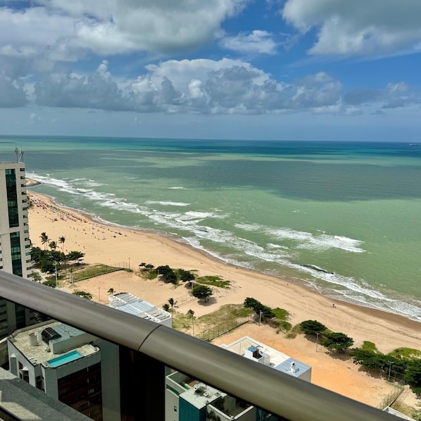 Vista de la playa desde un edificio alto, con cielo despejado y mar.