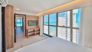 Une chambre d’hôtel moderne avec un grand lit, une télévision et une vue sur la ville.