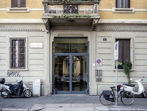 A building entrance with a glass door, a sign reading "Via Giulio Urbati," and a no parking sign. - VFH Stylish Boutique Apartment Central (Milan)