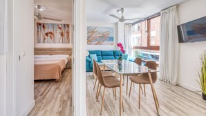 Een moderne hotelkamer met een eethoek, een bank en een televisie.