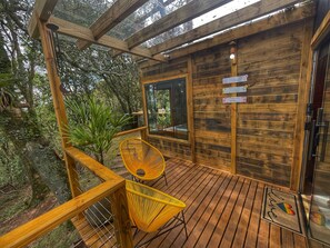 Una baita di legno con veranda, una porta vetrata e un cartello che indica accesso privato.