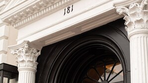 A black door with a white number "181" above it, flanked by white columns with ornate capitals. - Charleston Suite | 2 King Beds + Luxe Interiors (Charleston)
