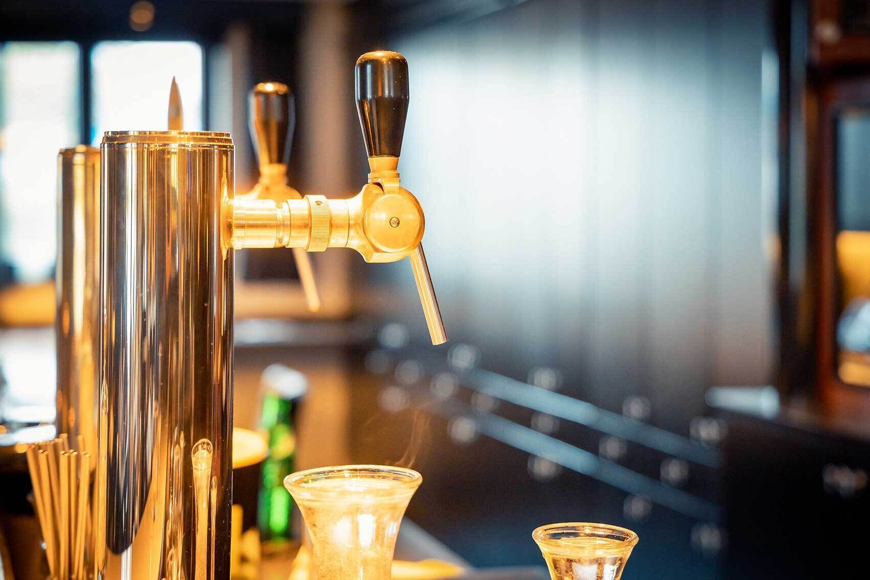 A bar area with a tap and glasses.