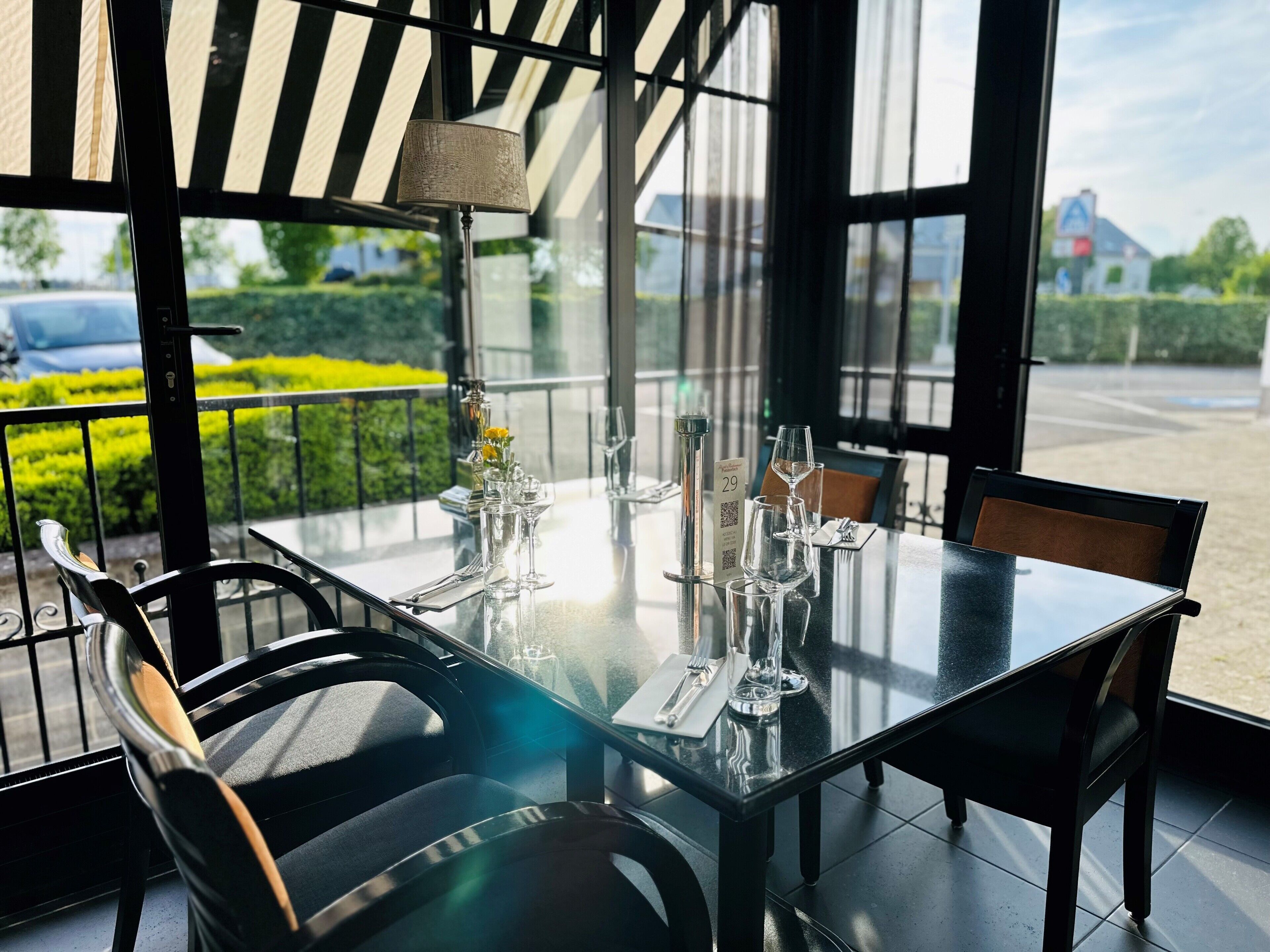 A dining table set with chairs, a lamp, and a menu.