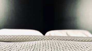 Primer plano de un tejido texturizado, probablemente parte de un edredón o tapicería, con un diseño de diamantes.