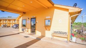 A motel with a single-story structure, a front desk, and a small outdoor seating area. - Regency Inn By OYO Rockdale TX (Rockdale)