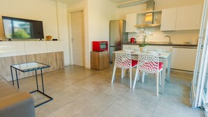 A modern kitchen with a dining area, a TV, and a small table. - Garda Hideaway - Italian Homing (Peschiera del Garda)