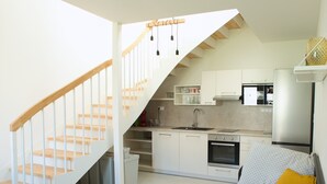 Een moderne keuken met witte kastjes, een ingebouwde oven en een roestvrijstalen koelkast.