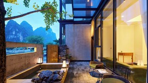 A modern spa area with a stone wall, a hot tub, and seating. - Yangshuo The One Hotel (Guilin)