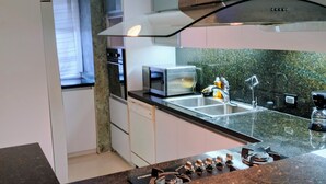 Eine moderne Küche mit einer Granit-Arbeitsplatte, Edelstahlgeräten und einer grünen Spritzschutzwand.