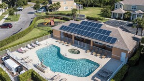 Un immeuble résidentiel doté d’une piscine, de panneaux solaires et d’une terrasse clôturée.
