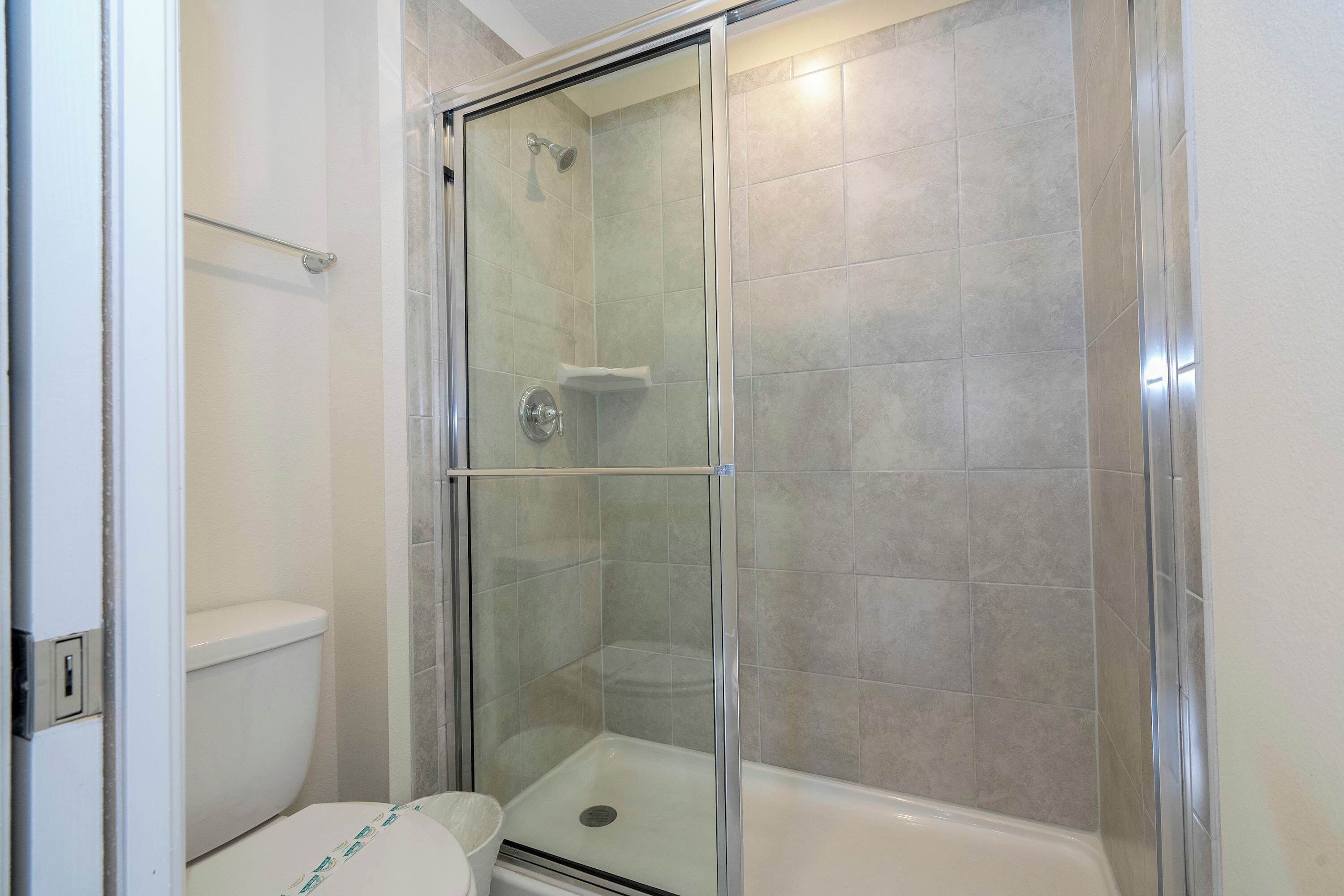 Une salle de bain avec une douche à parois de verre, des toilettes et une baignoire.