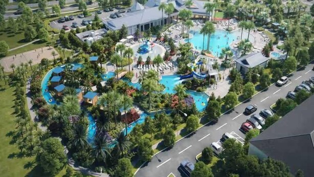 Eine Vogelperspektive eines Resorts mit mehreren Schwimmbecken, umgeben von Palmen und Hotelgebäuden.