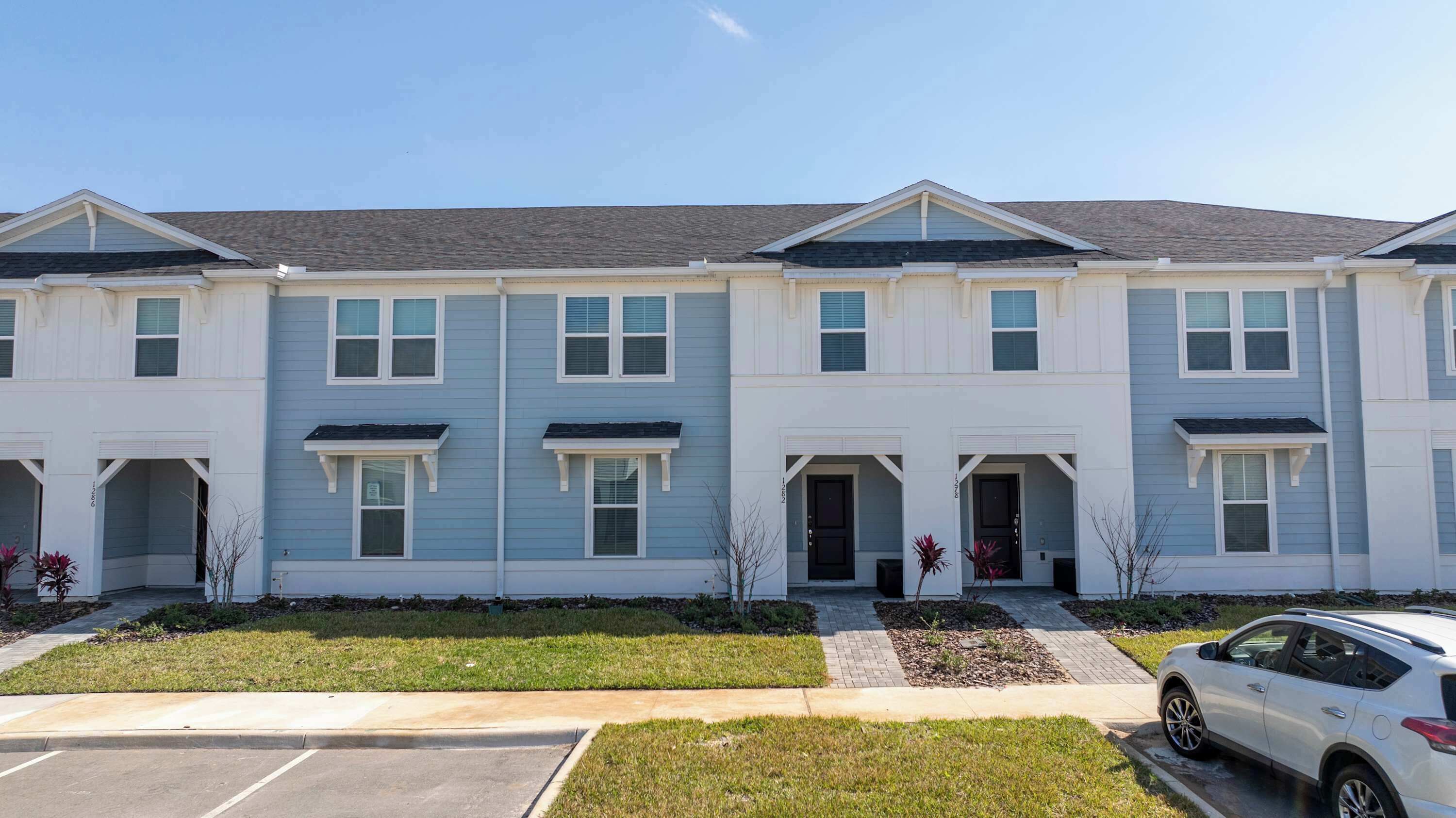 A row of townhouses with a parking lot in front.