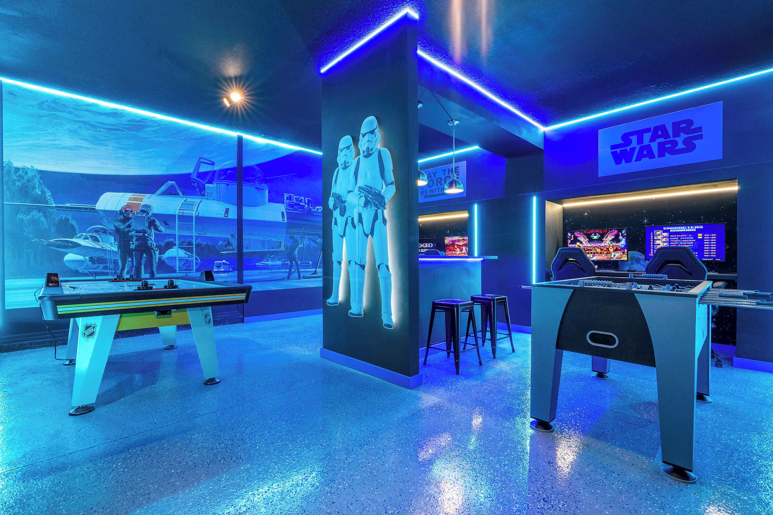 A Star Wars-themed room with a foosball table, a large mural of Stormtroopers, and a neon-lit ceiling.