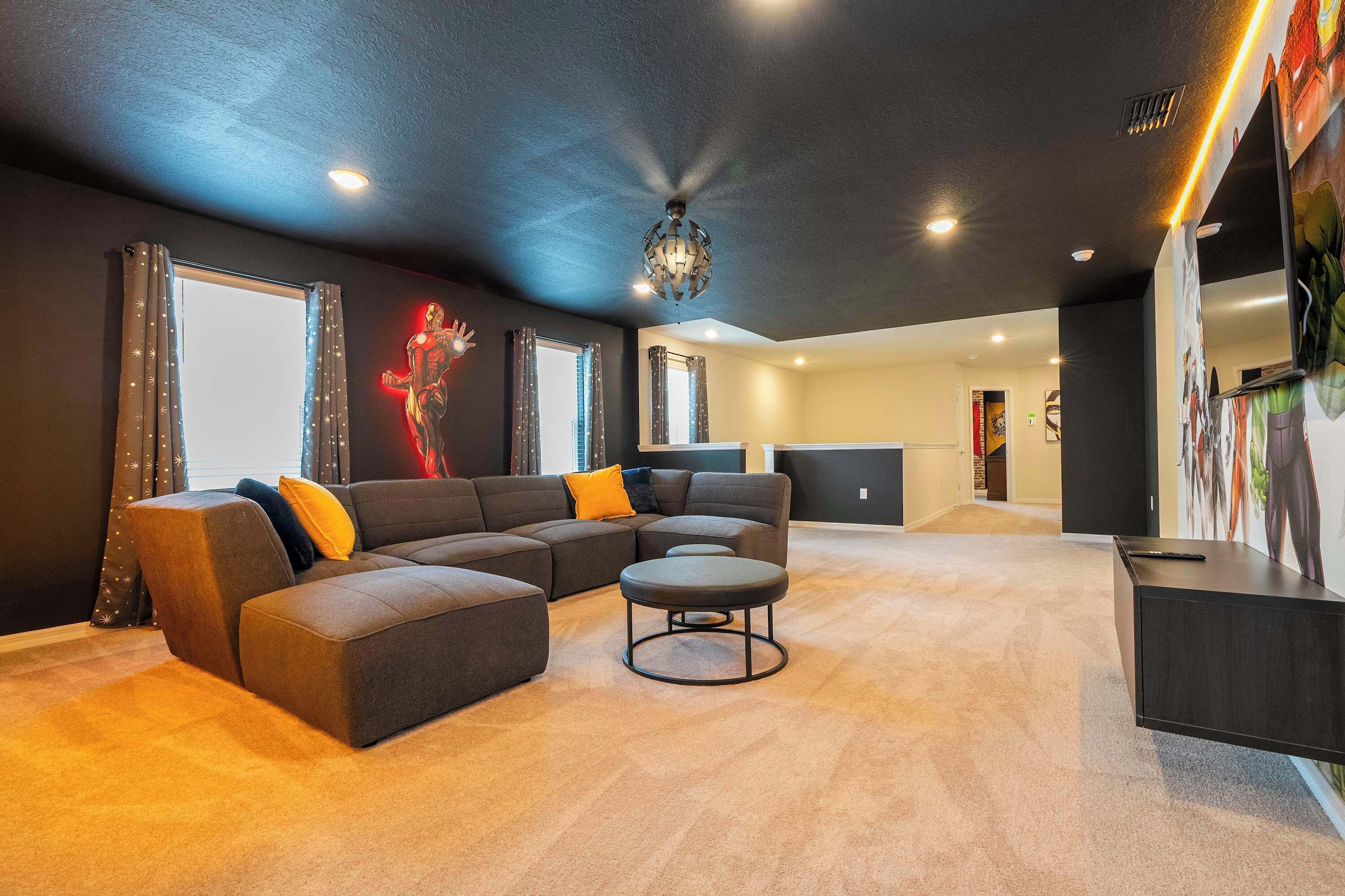 A modern living room with a sectional sofa, a round coffee table, and a dark accent wall.