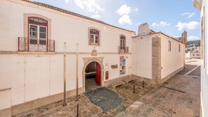 Un edificio con puerta roja, un pequeño arco y un cartel que dice "FORTALEZA VENTAS".
